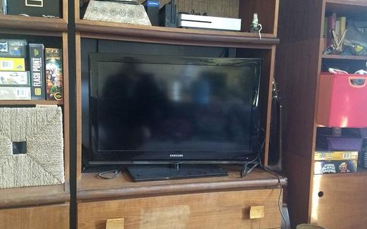 A flat-screen television in a bookshelf in the living room of a North American home