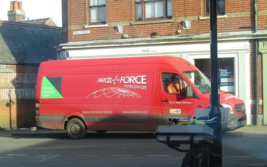 A Royal Mail parcel force delivery van parked on the High Street in the village of Mundesley , Norfolk, England
